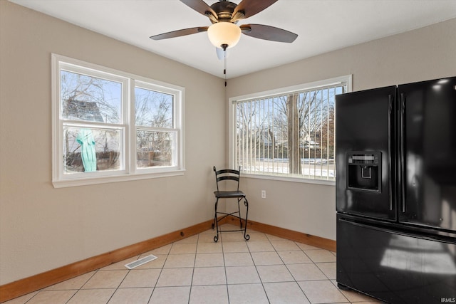 interior space with light tile patterned flooring, ceiling fan, and plenty of natural light