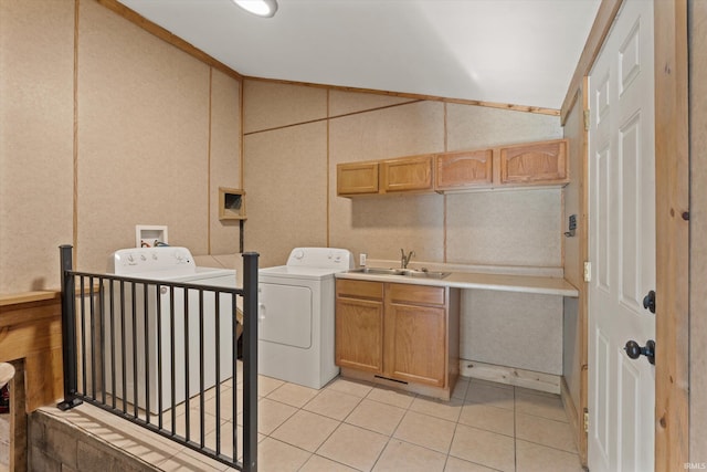 laundry area featuring cabinets, sink, light tile patterned floors, and washer and clothes dryer