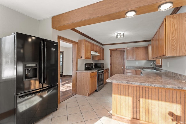 kitchen with sink, black fridge, light tile patterned flooring, gas range, and kitchen peninsula