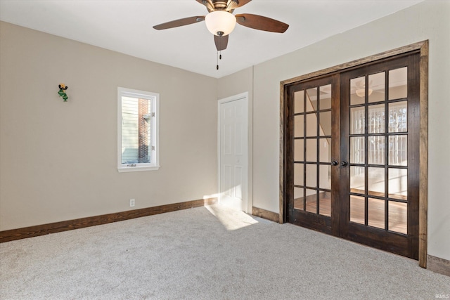 carpeted spare room featuring french doors and ceiling fan