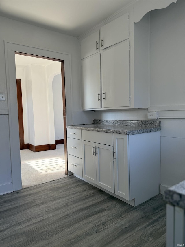 kitchen with dark wood-type flooring and white cabinets