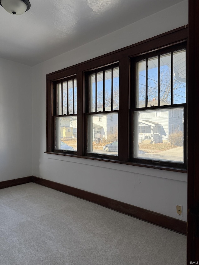 carpeted spare room featuring a healthy amount of sunlight