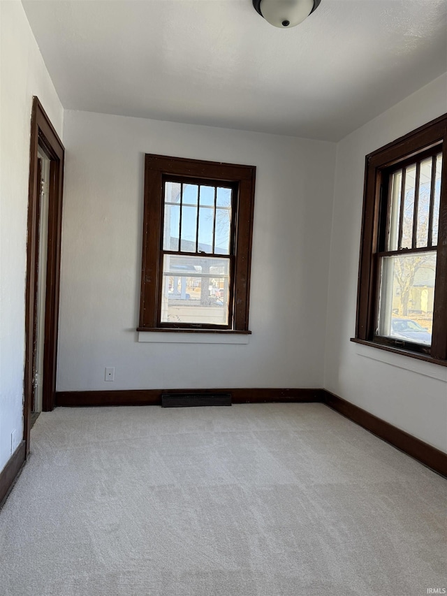 empty room featuring light colored carpet and a wealth of natural light