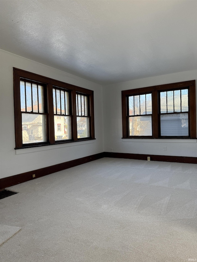 carpeted spare room with a textured ceiling