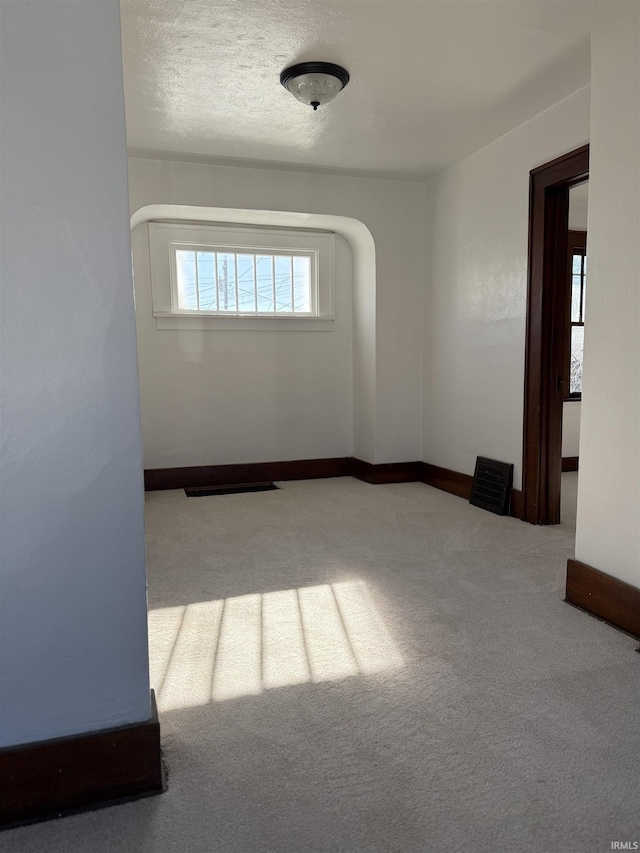 spare room with carpet flooring and a textured ceiling