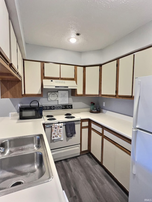 kitchen with white cabinetry, sink, white appliances, dark wood-type flooring, and a textured ceiling