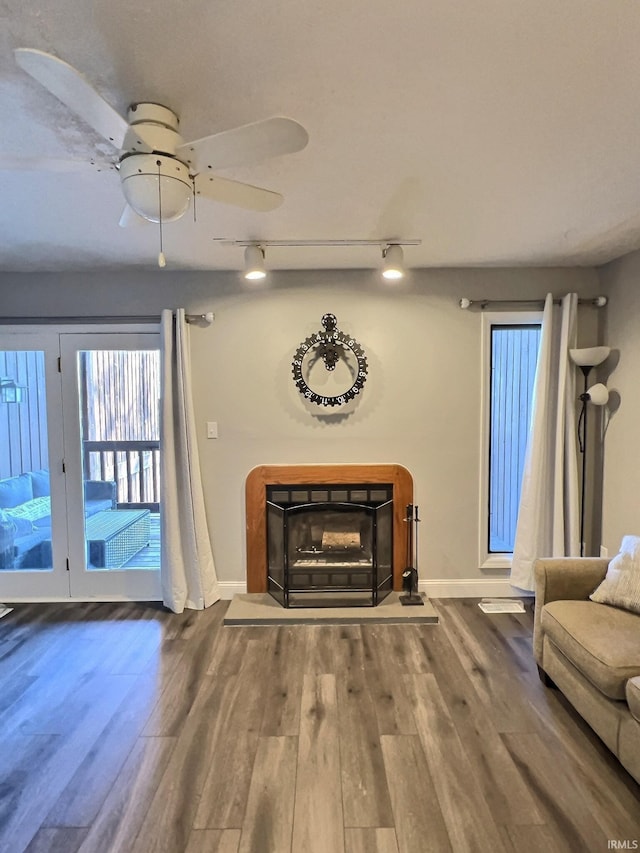 unfurnished living room featuring wood-type flooring and track lighting