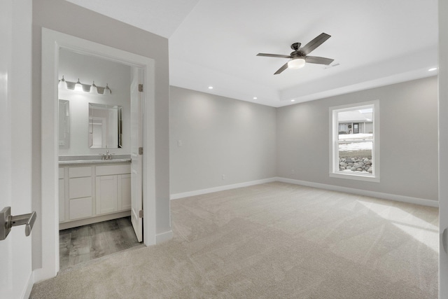 carpeted empty room with ceiling fan and sink