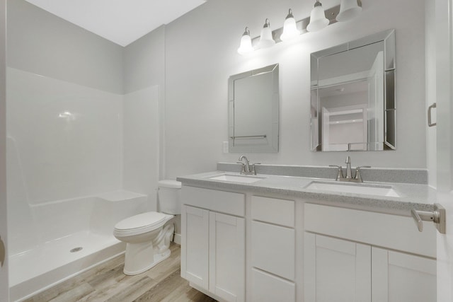 bathroom featuring vanity, hardwood / wood-style floors, toilet, and walk in shower