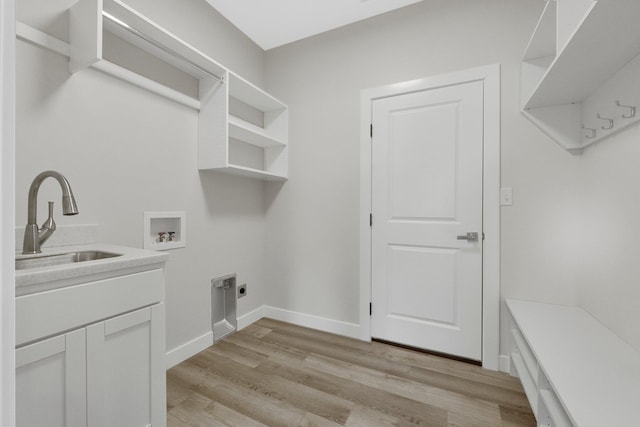 laundry room with sink, cabinets, hookup for a washing machine, hookup for an electric dryer, and light hardwood / wood-style floors