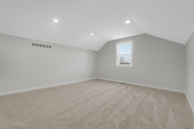 bonus room with light colored carpet and lofted ceiling