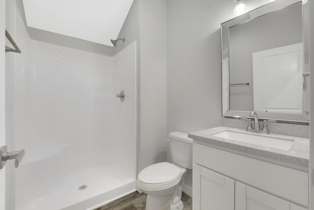 bathroom with vanity, toilet, hardwood / wood-style floors, and a shower