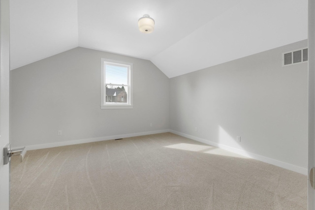 additional living space with light colored carpet and lofted ceiling