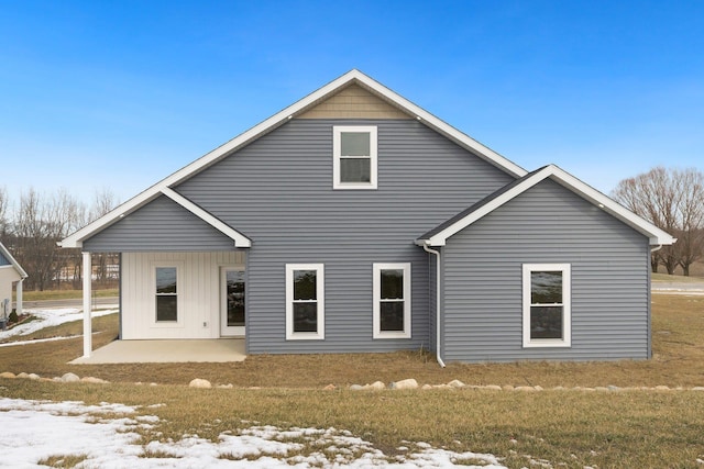 snow covered property with a patio area and a lawn