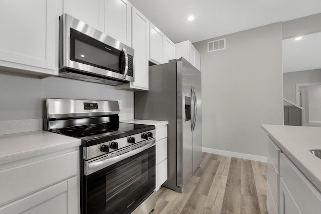 kitchen featuring light hardwood / wood-style flooring, stainless steel appliances, and white cabinets