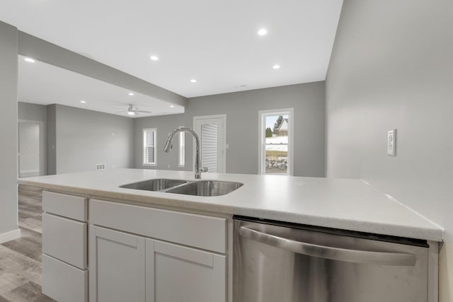 kitchen featuring sink, white cabinetry, light hardwood / wood-style flooring, stainless steel dishwasher, and ceiling fan