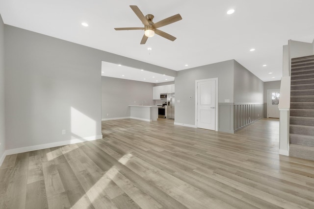 unfurnished living room featuring sink, light hardwood / wood-style floors, and ceiling fan