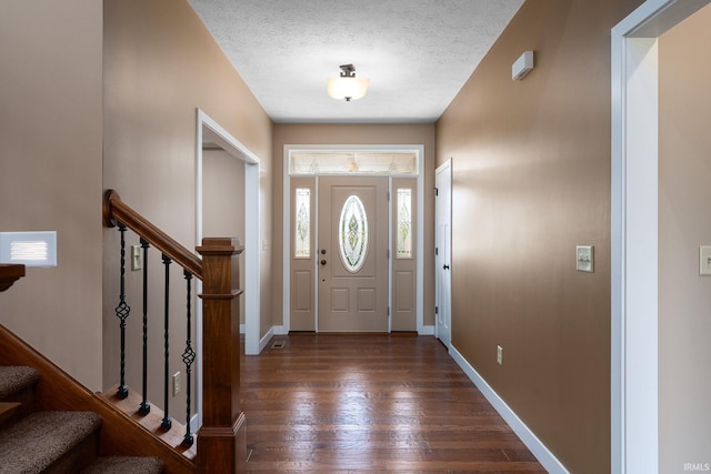 foyer entrance featuring dark hardwood / wood-style floors and a textured ceiling