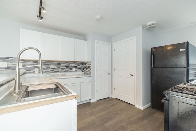 kitchen with sink, black appliances, white cabinets, dark hardwood / wood-style flooring, and decorative backsplash