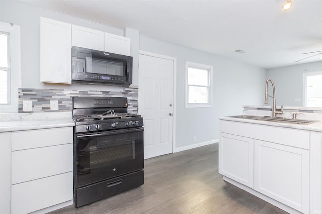 kitchen with sink, white cabinets, backsplash, black appliances, and plenty of natural light