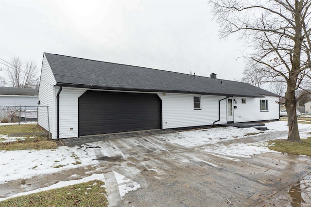 snow covered property with a garage