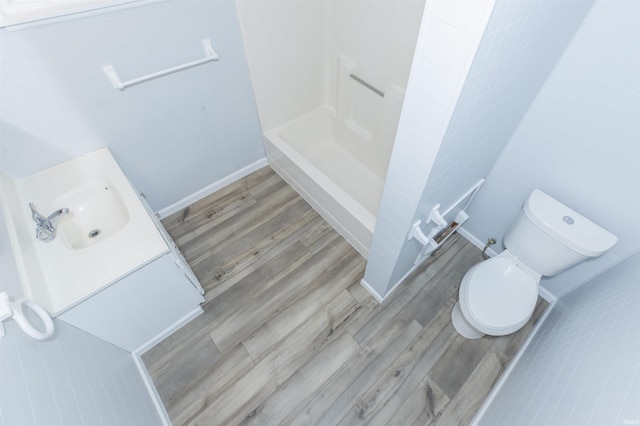 bathroom with walk in shower, wood-type flooring, toilet, and vanity