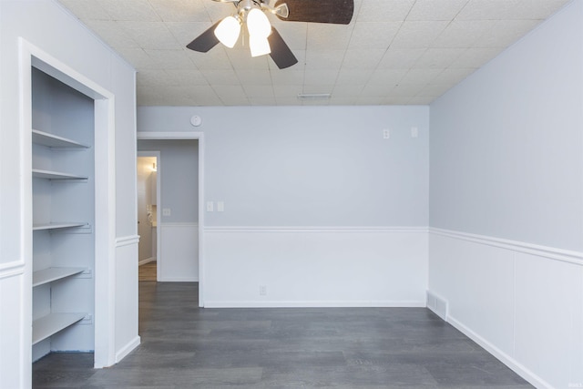 spare room with ceiling fan, built in features, and dark hardwood / wood-style flooring