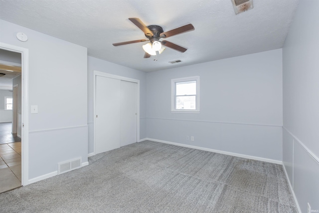 unfurnished bedroom with a closet, carpet, and a textured ceiling