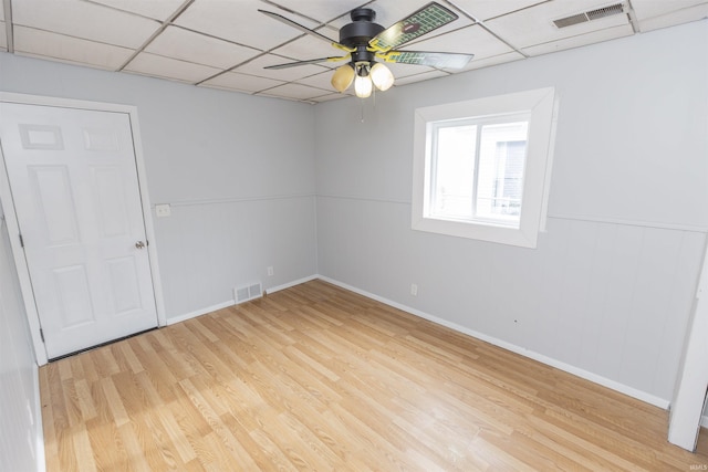 spare room with ceiling fan, a paneled ceiling, and light wood-type flooring