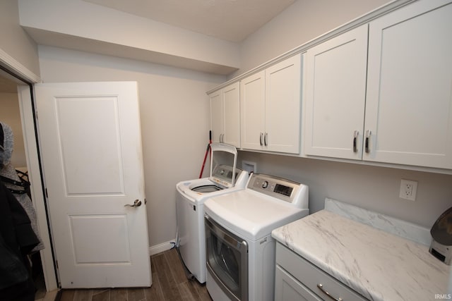 clothes washing area featuring independent washer and dryer, cabinets, and dark hardwood / wood-style flooring