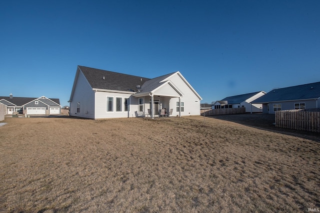 back of house featuring a garage and a yard