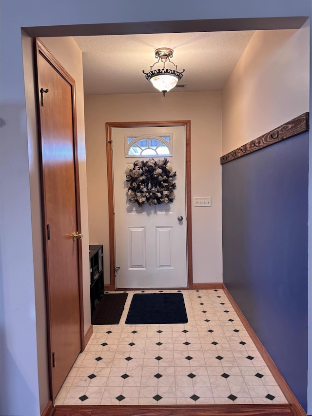 doorway to outside with a textured ceiling