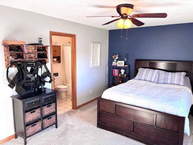 carpeted bedroom with ensuite bathroom and ceiling fan