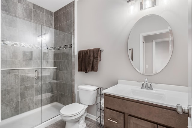 bathroom featuring a shower with door, vanity, and toilet