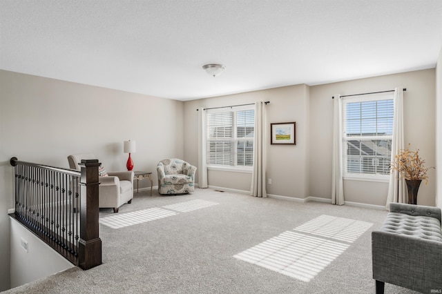 living area with a wealth of natural light and light colored carpet