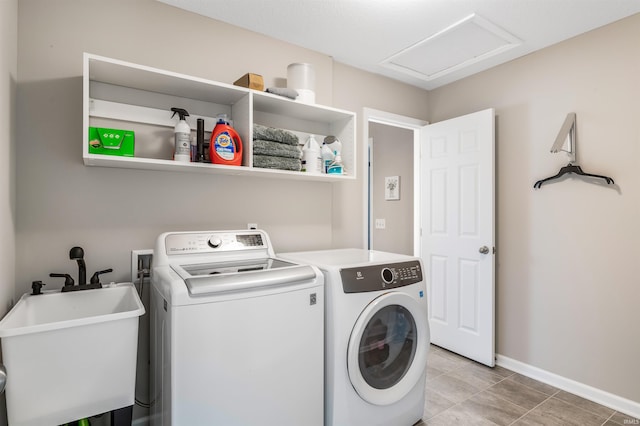 washroom featuring washing machine and dryer, sink, and light tile patterned floors