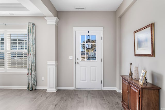 foyer with light hardwood / wood-style flooring and ornate columns