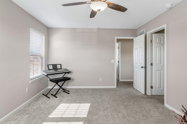 interior space with ceiling fan and light colored carpet