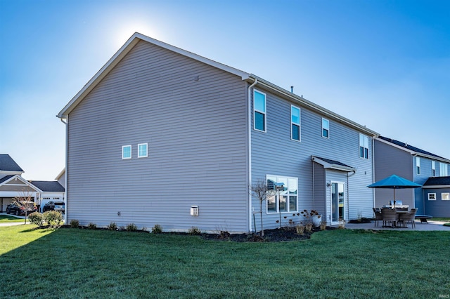 rear view of house with a patio and a yard