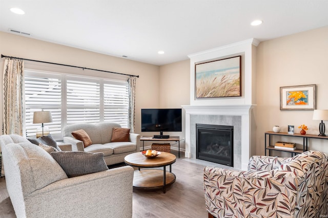 living room with hardwood / wood-style flooring and a tiled fireplace