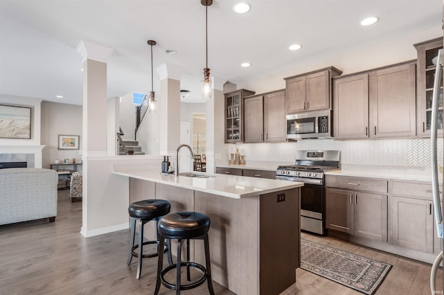 kitchen with appliances with stainless steel finishes, sink, pendant lighting, and decorative backsplash