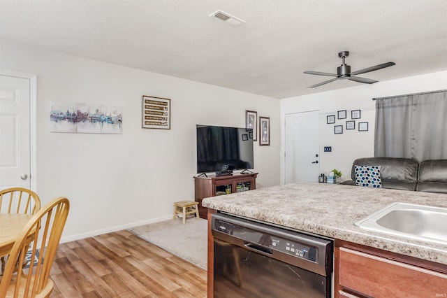 kitchen featuring ceiling fan, sink, dishwasher, and light wood-type flooring