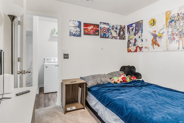 bedroom featuring wood-type flooring and washer / dryer