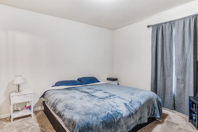 bedroom with light colored carpet and a textured ceiling