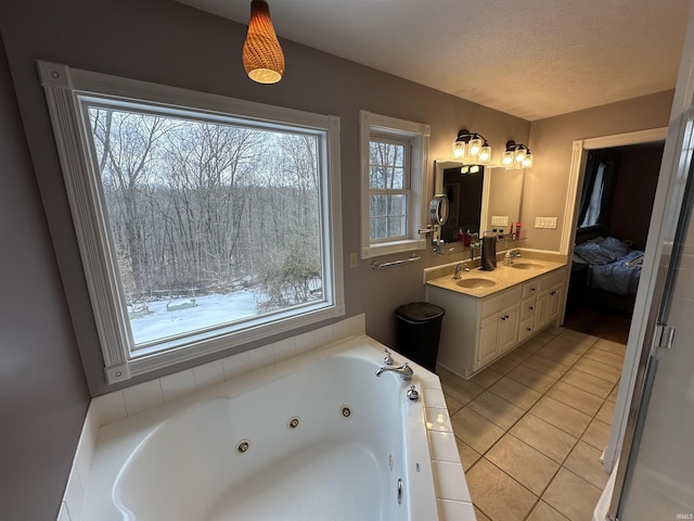 bathroom featuring vanity, a tub to relax in, tile patterned floors, and a textured ceiling