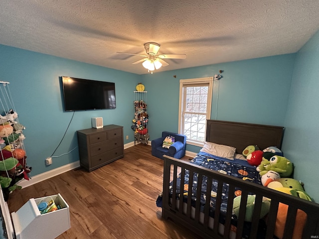 bedroom with hardwood / wood-style floors, a textured ceiling, and ceiling fan