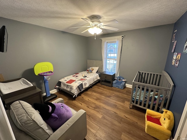 bedroom featuring a textured ceiling, wood-type flooring, and ceiling fan