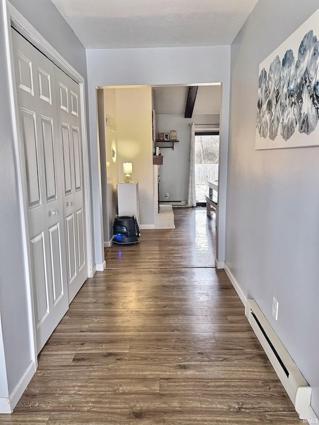 hall with beamed ceiling, dark hardwood / wood-style floors, and a baseboard heating unit