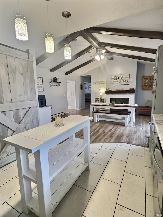 kitchen with light tile patterned flooring, pendant lighting, vaulted ceiling with beams, ceiling fan, and a barn door