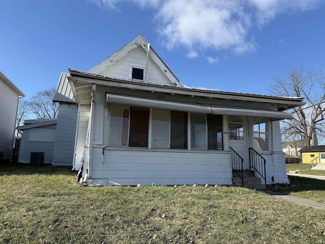 view of front of home with a front yard and central air condition unit